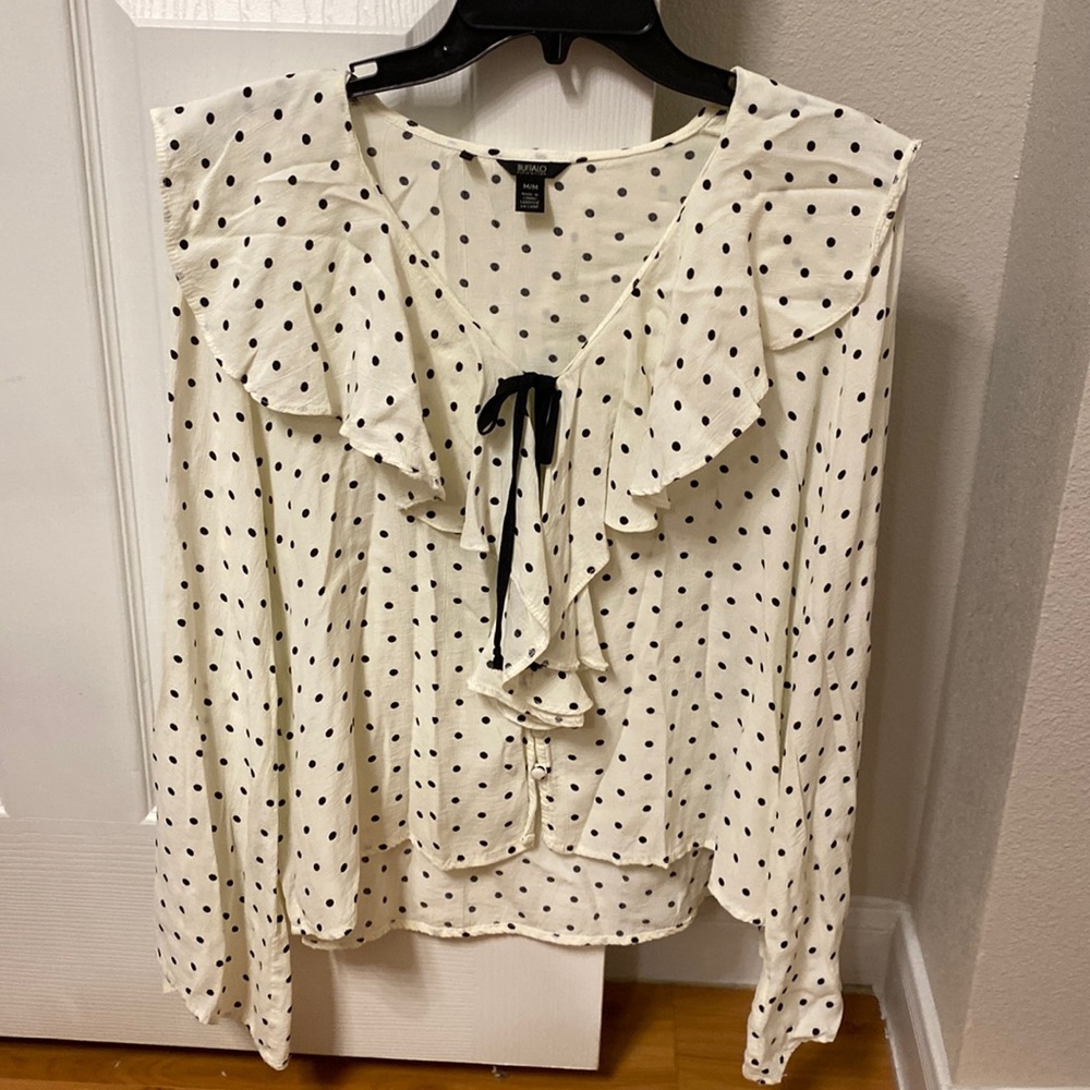 Polka dotted blouse with ruffles around the neck